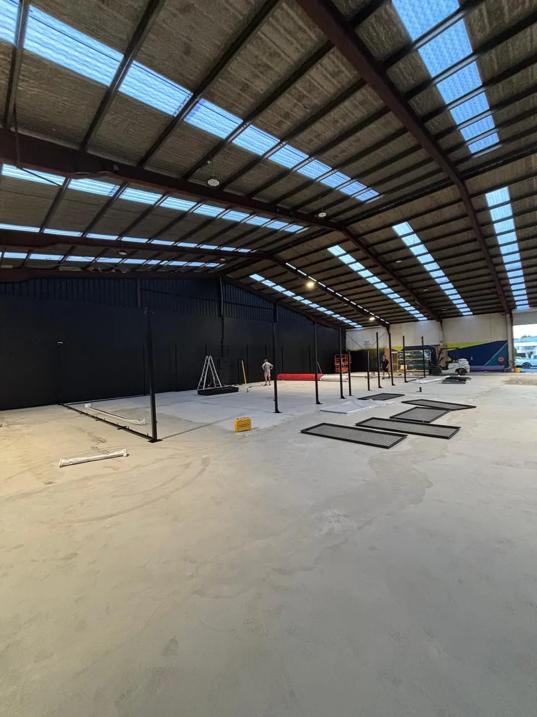 Black court frame posts standing on the bare warehouse floor
