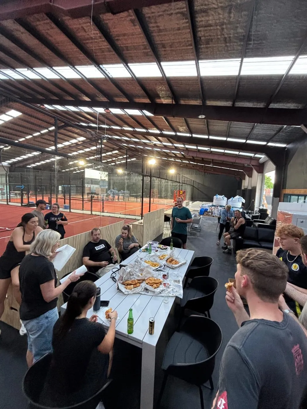 A group sharing fish and chips at a table beside the new red courts