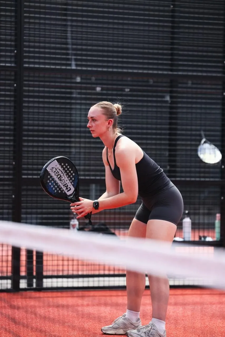 A player waiting for the ball at the net on a padel court