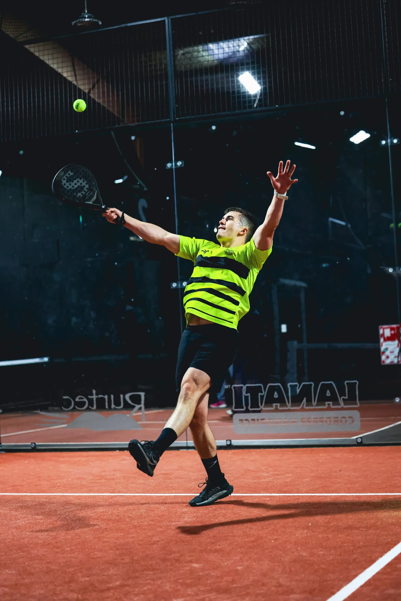 A padel player playing a bandeja on court 2